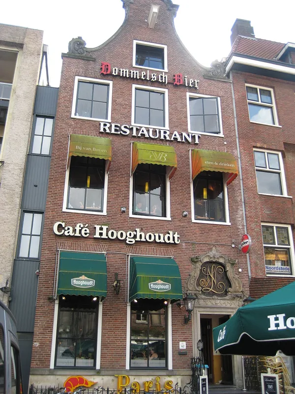 Brick canal-house facade at Grote Markt 42 Groningen with Cafe Hooghoudt signage and green awnings