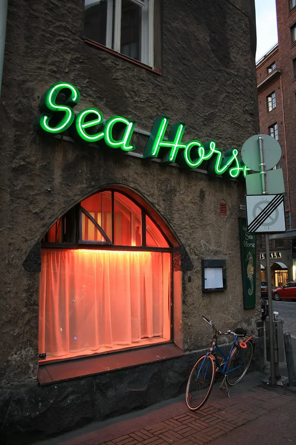 Exterior of Sea Horse restaurant in Helsinki with green neon sign