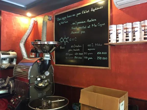Interior of Mia Coffee in Hoi An showing roasting machine and chalkboard menu with 'Fresh roasted at Mia Coffee'