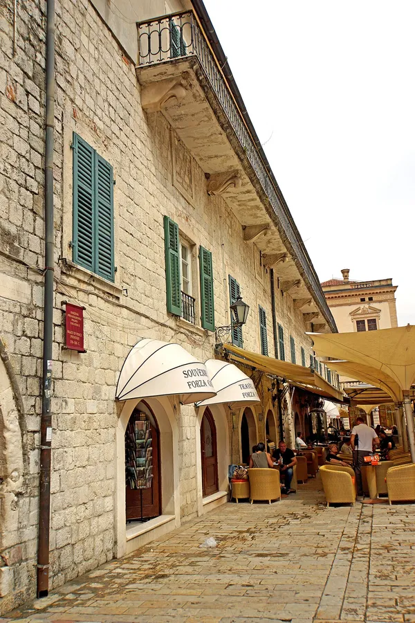 Forza Cafe's arched arcade with dome awnings and outdoor seating along the Prince's Palace colonnade in Kotor Old Town