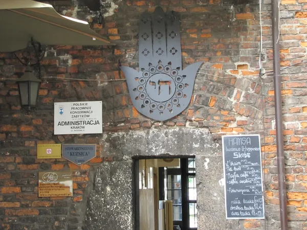 Entrance to Hamsa Hummus and Happiness restaurant, Krakow, with Hamsa symbol and menu board