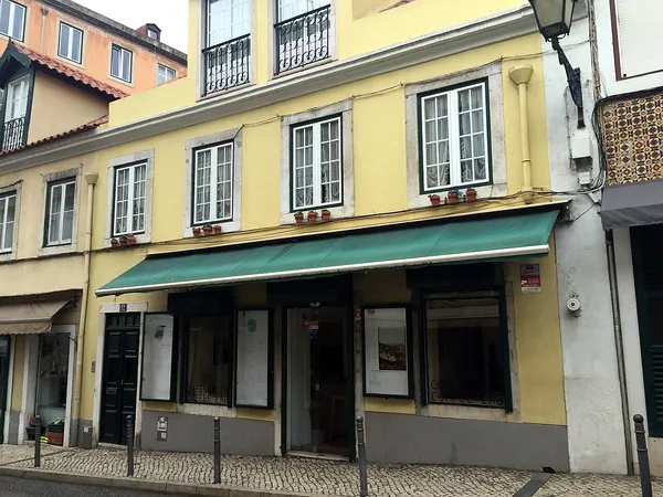 Copenhagen Coffee Lab storefront with green awning in Lisbon