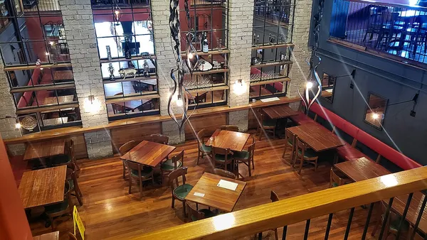 Interior dining room of République restaurant, Los Angeles, showing brick walls, mezzanine level, and warm industrial lighting
