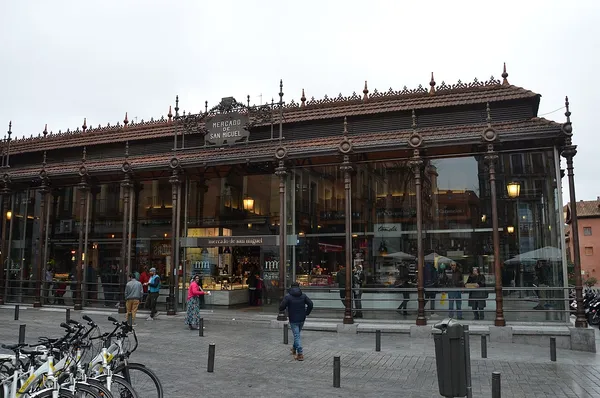 Exterior of Mercado de San Miguel in Madrid, a historic iron and glass market hall with ornate facade