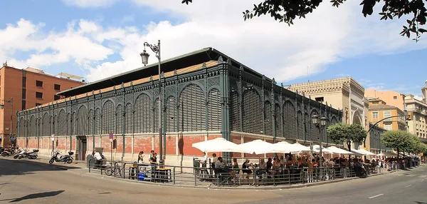 Exterior of Mercado de Atarazanas, Málaga, showing its ornate iron facade and outdoor seating