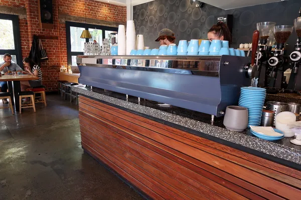 Interior of Proud Mary coffee bar in Collingwood, Melbourne, with espresso machine and blue ceramic cups