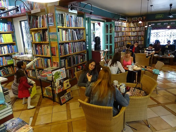 Interior of El Pendulo bookstore-cafe in Condesa, Mexico City, with shelves of books and cafe seating