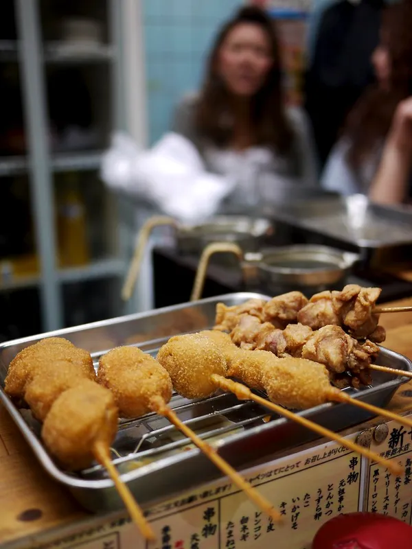Kushikatsu skewers on a metal tray at Daruma Shinsekai, Osaka