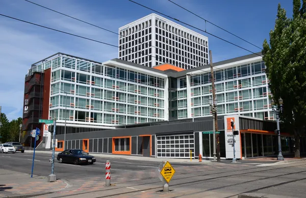 Exterior of Hotel Eastlund in Portland's Lloyd District showing the modern glass and orange facade