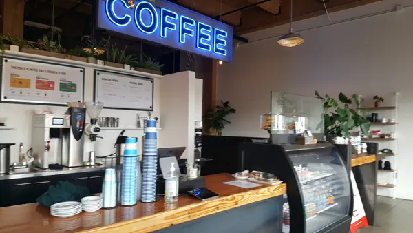 Interior of Water Avenue Coffee showing the bar counter with a large blue neon COFFEE sign