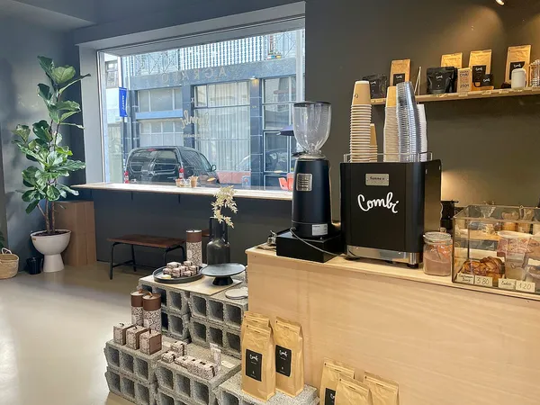Interior of Combi Coffee Roasters in Porto showing the counter with espresso machine and coffee bags