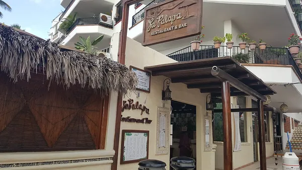 La Palapa Restaurant and Bar entrance with wooden sign and palapa roof, Puerto Vallarta