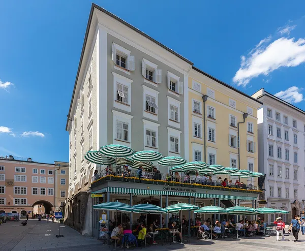 Cafe Tomaselli exterior with green-striped umbrellas on Alter Markt, Salzburg
