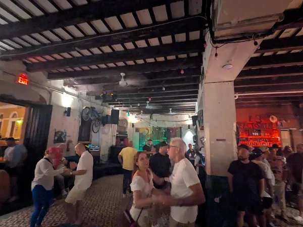 Interior of La Factoria bar in Old San Juan with neon sign and crowded dance floor