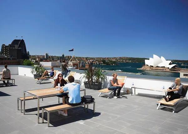 Rooftop terrace of YHA Sydney Harbour hostel in The Rocks, with Sydney Opera House and Harbour Bridge in the background