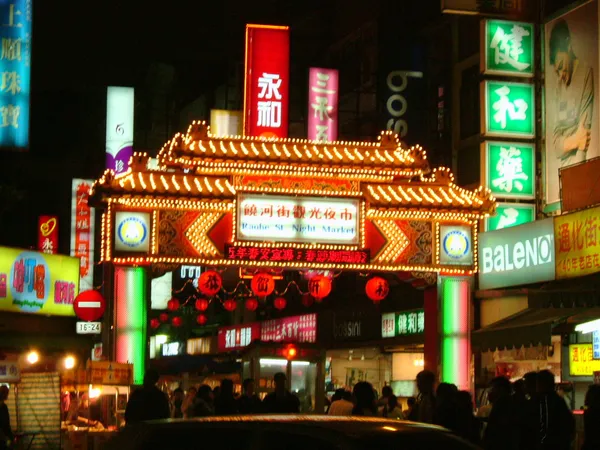Illuminated entrance gate of Raohe Street Night Market at night, Taipei