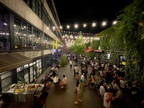 Fabrika Tbilisi courtyard at night with crowds, string lights and colourful bunting