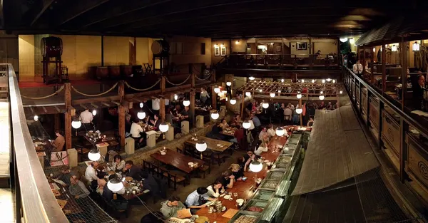 Multi-level wood-beamed interior of Gonpachi Nishi-Azabu restaurant with round globe lanterns and long dining tables