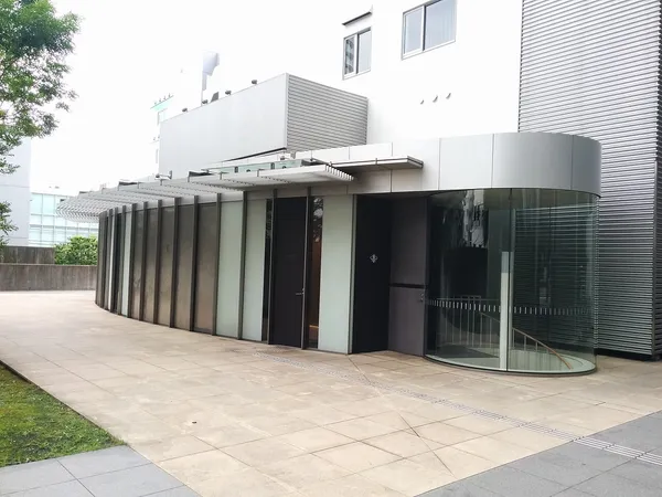 Modern curved glass and metal exterior of Narisawa restaurant in Minami-Aoyama, Tokyo