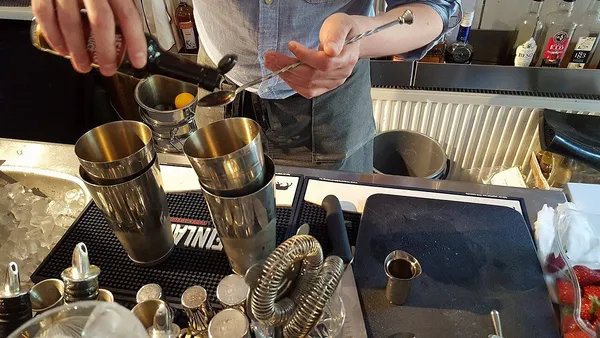 Bartender preparing a cocktail at the bar counter inside Tiirikkala cafe-restaurant in Turku