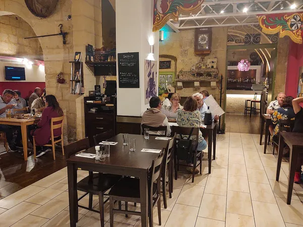 Interior of Nenu the Artisan Baker restaurant in Valletta, Malta, showing dining tables and traditional decor